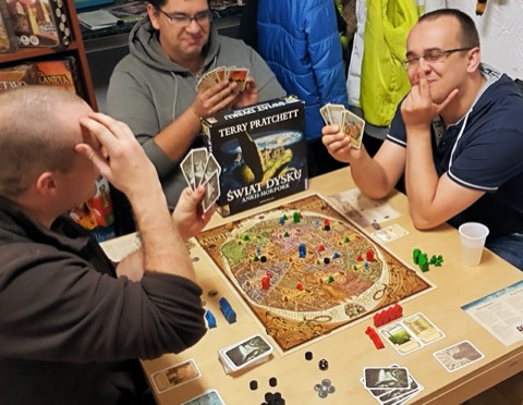 Friends playing a board game around a table