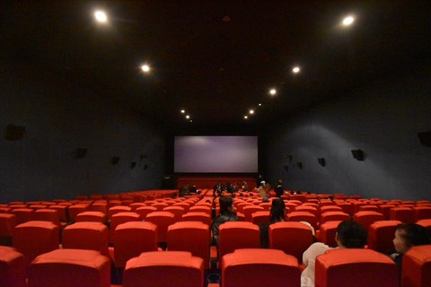 Rows of red seats facing a cinema screen