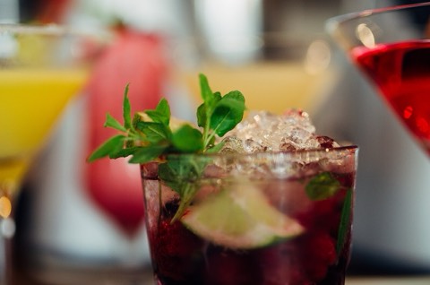Bright cocktails with mint and lime lined up on a bar counter