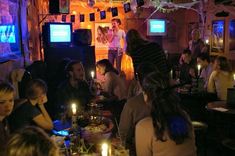 A pub crowd watching someone sing karaoke
