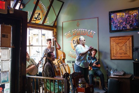 A jazz band with trumpet, clarinet and double bass playing in a small music bar