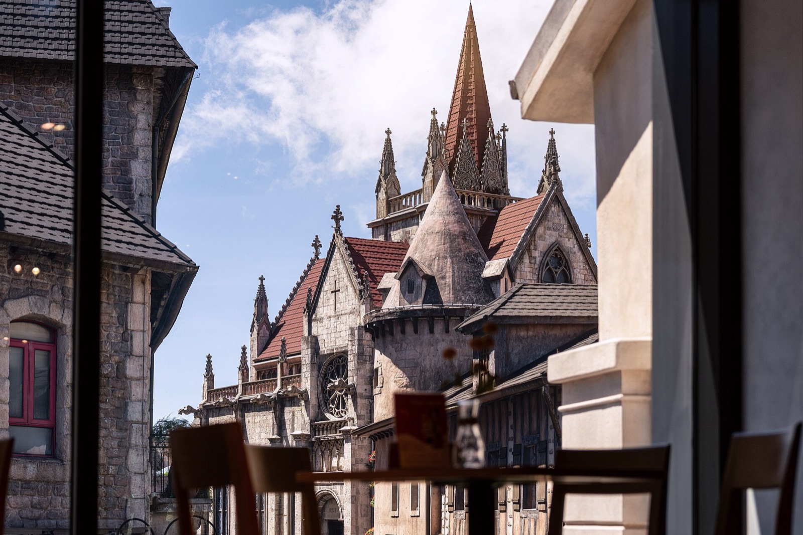 Gothic-style spires and stone buildings of the French Village replica at Ba Na Hills under a blue sky