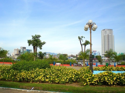 A finished, landscaped stretch of the Bach Dang riverfront walkway with palms, flowers and lamp posts