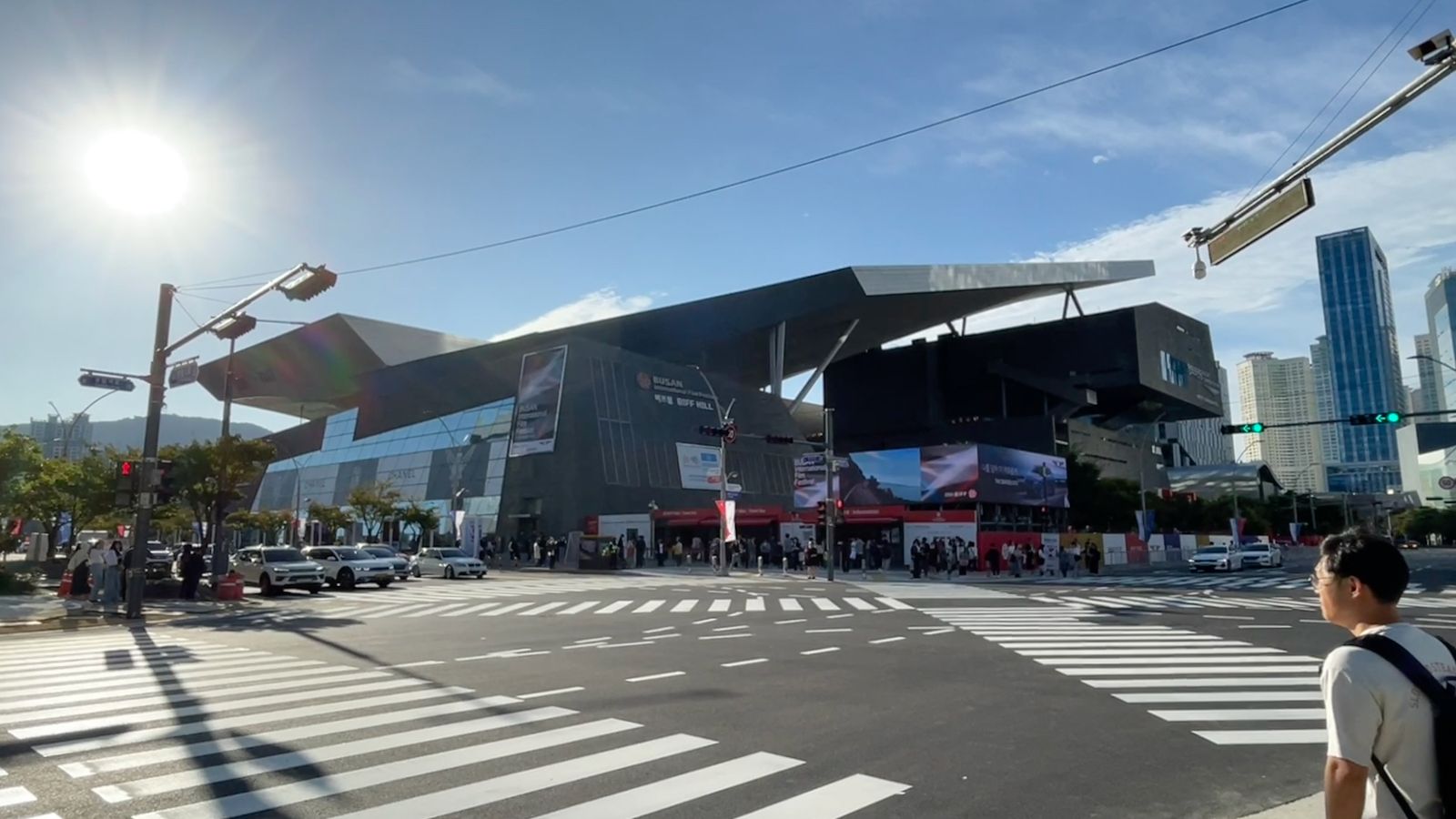 The angular, cantilevered roof of the Busan Cinema Center above a wide pedestrian crossing