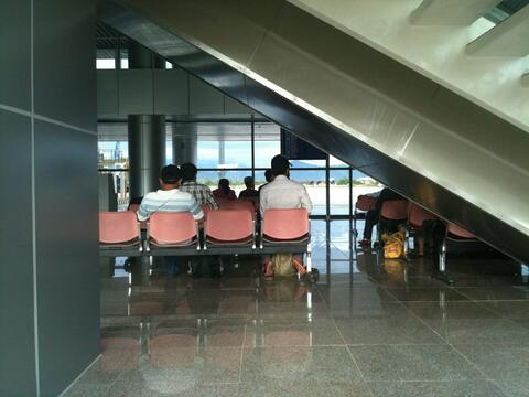Passengers sitting and standing near a boarding gate inside Da Nang International Airport