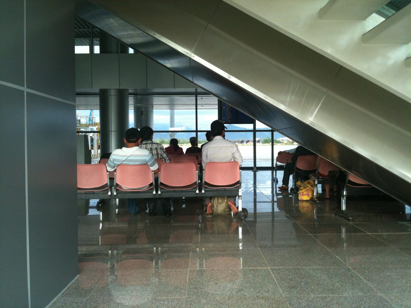 Passengers sitting and standing near a boarding gate inside Da Nang International Airport