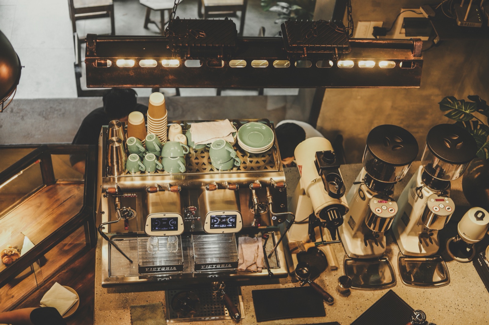 A vintage-style Vietnamese cafe counter with coffee equipment, jars and warm lighting