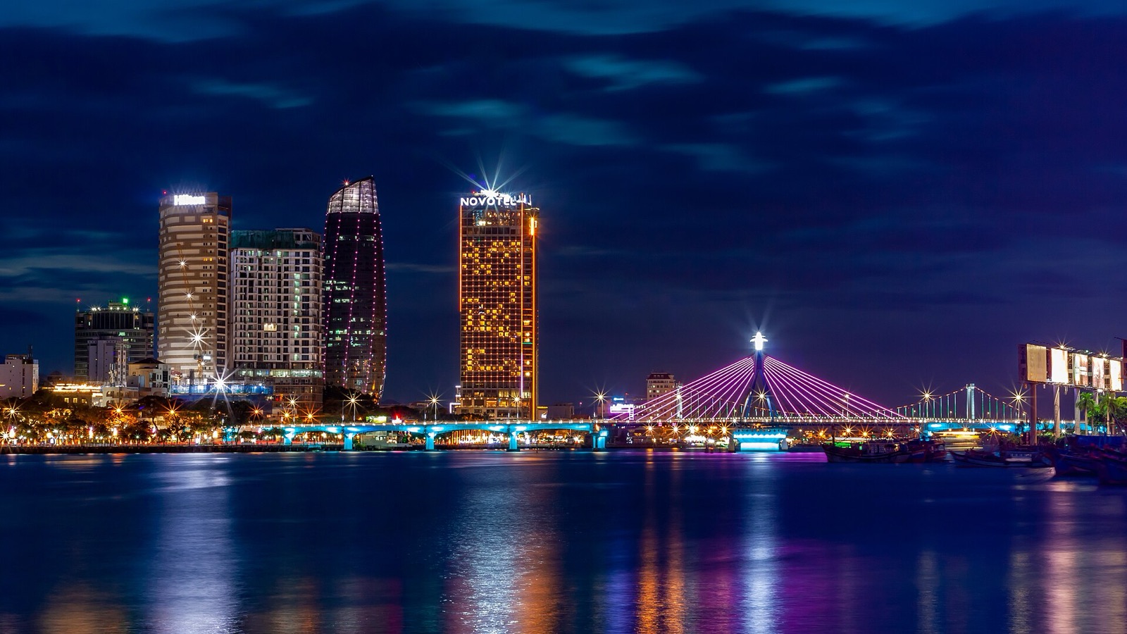 A cable-stayed bridge over the Han River lit up at night with city lights along the bank