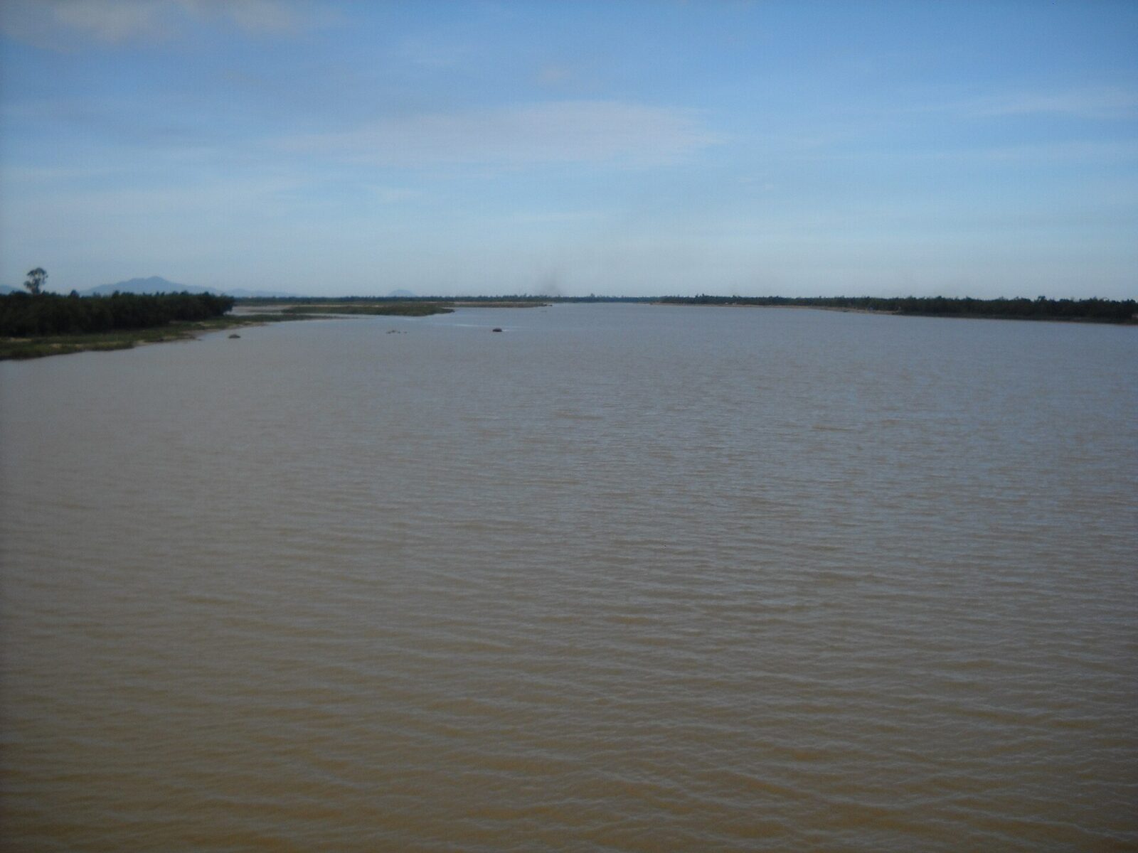 The Thu Bon River flowing between green banks in Quang Nam